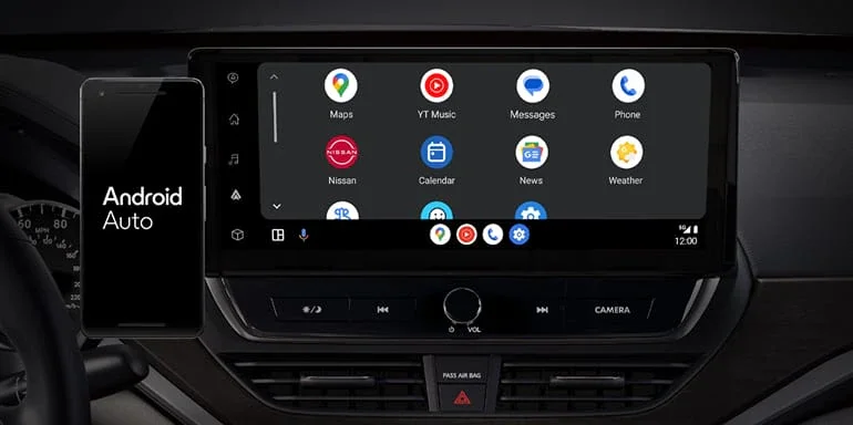A smartphone with Android Auto on screen next to a car infotainment system displaying various app icons.